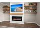 Modern electric fireplace with a beach scene TV above and custom built-in shelving at 131 Beargrass Ln, Summerville, SC 29486