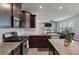 A stunning kitchen with stainless steel appliances, granite counters, and dark wood cabinets at 1311 Berry Grove Dr, Summerville, SC 29485