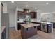 A modern kitchen features stainless steel appliances, granite counters, and dark wood cabinets at 1311 Berry Grove Dr, Summerville, SC 29485