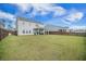 Spacious backyard with lush green grass, a dark wood fence, and a covered patio, perfect for outdoor living at 134 Lucca Dr, Summerville, SC 29486