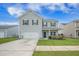 Charming two-story home with gray siding, attached garage, landscaped yard, and inviting front porch, perfect for relaxing outdoors at 134 Lucca Dr, Summerville, SC 29486
