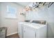 Well-lit laundry room includes a side-by-side washer and dryer, with a storage shelf above for supplies at 134 Lucca Dr, Summerville, SC 29486