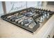 A close up of a stainless gas cooktop with heavy grates, chrome knobs and white countertops at 134 Lucca Dr, Summerville, SC 29486
