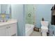 Light blue bathroom featuring a tub with glass doors and a white vanity at 1404 Palmetto Blvd, Edisto Beach, SC 29438