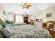 Bright bedroom with hardwood floors featuring two beds, ceiling fan, and double doors at 1404 Palmetto Blvd, Edisto Beach, SC 29438