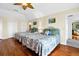 Spacious bedroom with hardwood floors featuring two beds and a ceiling fan at 1404 Palmetto Blvd, Edisto Beach, SC 29438
