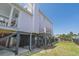 Charming side view of home with multiple decks, black support beams, and a spacious side yard at 1404 Palmetto Blvd, Edisto Beach, SC 29438