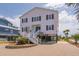 Charming two-story beach house with black shutters, a well-maintained brick driveway at 1404 Palmetto Blvd, Edisto Beach, SC 29438