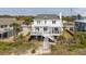 Charming raised beach house featuring a large deck, fenced yard, and private beach access at 1404 Palmetto Blvd, Edisto Beach, SC 29438