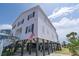 Charming two-story beach house with black shutters and well-maintained landscaping at 1404 Palmetto Blvd, Edisto Beach, SC 29438