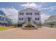 Charming two-story beach house with black shutters and a well-maintained brick driveway at 1404 Palmetto Blvd, Edisto Beach, SC 29438