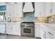 Bright kitchen features stainless appliances, quartz countertops, and chic tile backsplash at 1404 Palmetto Blvd, Edisto Beach, SC 29438