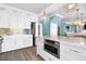 Open kitchen boasts white cabinets, stainless appliances, and a view to the dining room at 1404 Palmetto Blvd, Edisto Beach, SC 29438