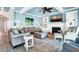 Bright living room boasts a fireplace, ceiling fan, plush seating and beachy accents at 1404 Palmetto Blvd, Edisto Beach, SC 29438
