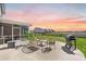 Expansive backyard with a screened porch, outdoor seating area, grill, and pond view at 142 Lucca Dr, Summerville, SC 29486