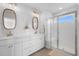 Bright bathroom featuring a double vanity, stylish mirrors, and a glass-enclosed shower with a built-in seat at 142 Lucca Dr, Summerville, SC 29486