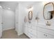 Bright bathroom featuring a double vanity, stylish mirrors, and white cabinetry with brass fixtures at 142 Lucca Dr, Summerville, SC 29486