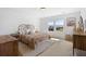Sunlit bedroom features a rattan headboard bed, modern furnishings, and a large window with a view at 142 Lucca Dr, Summerville, SC 29486