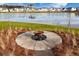 Outdoor fire pit overlooking the serene lake, providing a cozy and inviting space for relaxation at 142 Lucca Dr, Summerville, SC 29486