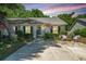 Charming home featuring a manicured lawn, decorative chairs, and mature trees in a tranquil setting at 1571 Blaze Ln, Charleston, SC 29412