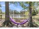Beautiful backyard view with hammock strung between mature trees, overlooking a serene lake at 1733 James Basford Pl, Mount Pleasant, SC 29466