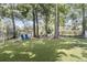 Enjoy outdoor activities in this backyard featuring artificial turf, two blue Adirondack chairs, and a scenic lake view at 1733 James Basford Pl, Mount Pleasant, SC 29466