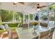 Screened porch with dining table, comfortable seating, and ceiling fans, perfect for outdoor entertaining at 1733 James Basford Pl, Mount Pleasant, SC 29466