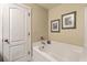 Bathroom featuring a white tub, shower combo, framed art, and a door, designed for a practical layout at 1781 Brittlebush Ln, Johns Island, SC 29455