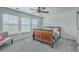 Bedroom featuring a dark wood sleigh bed, three windows, and neutral tones, creating a serene retreat at 1781 Brittlebush Ln, Johns Island, SC 29455