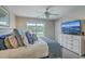 Bedroom features a king bed, ceiling fan, balcony access, dresser with mounted TV, and ample natural light at 1781 Brittlebush Ln, Johns Island, SC 29455