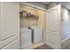 Convenient laundry room with a washer, dryer, and built-in storage shelves at 1781 Brittlebush Ln, Johns Island, SC 29455