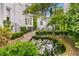 Secluded backyard with a koi pond, lush greenery, and garden seating area at 184 Ashley Ave, Charleston, SC 29403