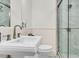 Well-lit bathroom features a pedestal sink, modern fixtures, and walk-in shower with marble tile at 184 Ashley Ave, Charleston, SC 29403