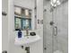 Bright bathroom featuring a modern vanity, shower with glass door, and marble wall tiles at 184 Ashley Ave, Charleston, SC 29403