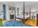 Bedroom featuring a fireplace, four-poster bed, and hardwood floors with decorative blue rug at 184 Ashley Ave, Charleston, SC 29403
