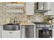 A stylish kitchen featuring stainless appliances, custom backsplash, and a farmhouse sink at 184 Ashley Ave, Charleston, SC 29403
