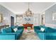 Living room with blue sofas, elegant chandelier, stylish wallpaper, and charming, sunlit windows at 184 Ashley Ave, Charleston, SC 29403