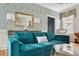 Living room featuring a comfortable blue sofa, decorative wallpaper, and elegant gold-framed mirror at 184 Ashley Ave, Charleston, SC 29403