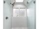Bright bathroom shower with glass enclosure, white tile, and patterned window accents at 184 Ashley Ave, Charleston, SC 29403