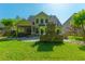 Beautiful backyard featuring a screened-in porch, stone fireplace, and lush green lawn, perfect for outdoor living at 204 Black Gum Cir, Moncks Corner, SC 29461