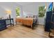 Bedroom featuring wood floors, two windows, and a side table with lamp at 213 Factors Walk, Summerville, SC 29485