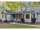 Inviting front porch with white railings and trim, complemented by large bay windows and well-maintained landscaping at 213 Factors Walk, Summerville, SC 29485