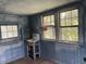 Bathroom featuring a vintage sink, wood-paneled walls, built-in shelving and natural light from multiple windows at 217 Scotia St, McClellanville, SC 29458