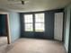 Light-filled bedroom with hardwood floors, blue walls, large windows and classic trim, ready for renovation at 217 Scotia St, McClellanville, SC 29458