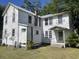 Rear exterior featuring a chimney, multiple windows, and an entry, surrounded by a green lawn at 217 Scotia St, McClellanville, SC 29458