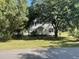 Traditional two-story home with a covered porch and mature trees, set on a spacious lawn at 217 Scotia St, McClellanville, SC 29458