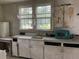 Vintage kitchen with original cabinetry, sink, and appliances with a view to the backyard, brimming with potential at 217 Scotia St, McClellanville, SC 29458