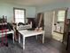 Renovation scene in living room with open doorway, vintage tables and chairs scattered around, highlighting a project in progress at 217 Scotia St, McClellanville, SC 29458