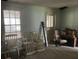Spacious living room with natural light from large windows, vintage chairs, rocking chair and hardwood floors at 217 Scotia St, McClellanville, SC 29458