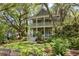 Charming two-story home with a double porch nestled among mature trees and professional landscaping at 2187 Saint James Dr, Charleston, SC 29412